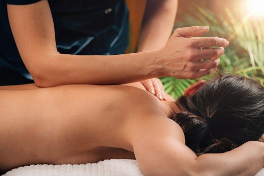 Deep Tissue Massage Therapy. Therapist massaging Woman’s Back, using Elbow Pressure.